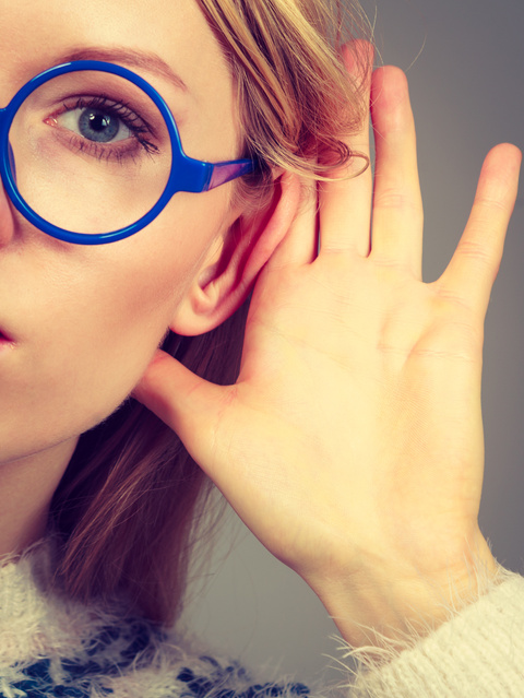 Woman listening carefully with hand close to ear